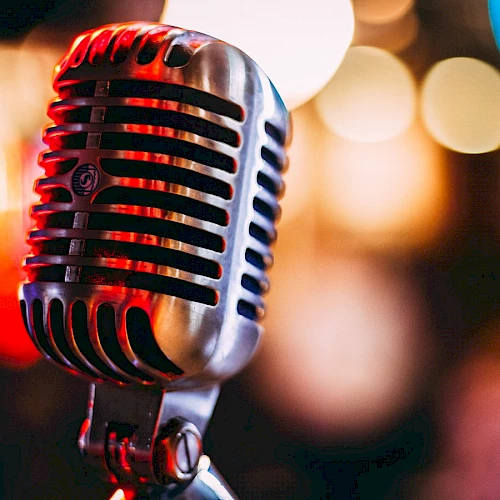 A vintage-style microphone with a blurred background of colorful lights, creating a vibrant and lively atmosphere.